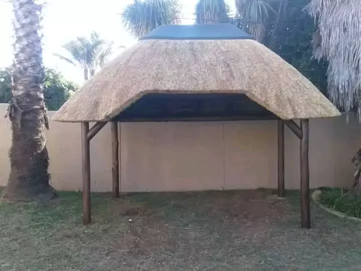 A thatched gazebo in an outdoor garden setting